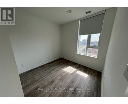 A room with a window and wooden flooring.