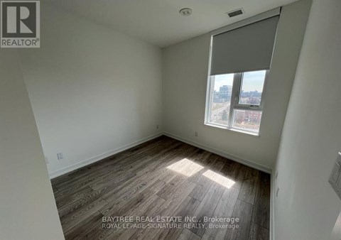 A room with a window and wooden flooring.