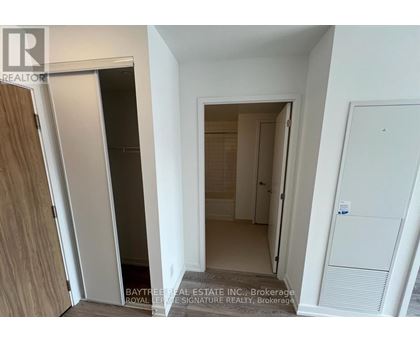 A white hallway with a door on the left and a door on the right.