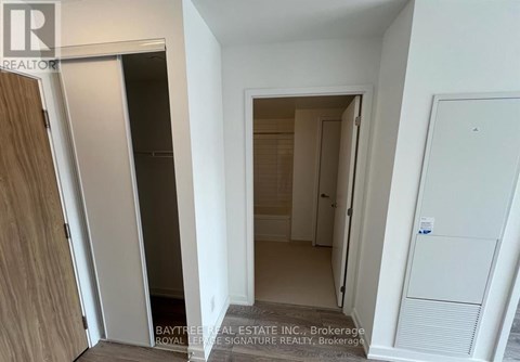 A white hallway with a door on the left and a door on the right.