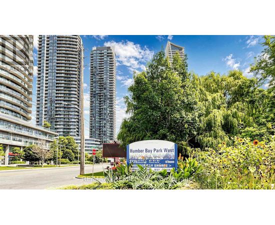 A sign for Humber Bay Park West stands in front of a row of tall buildings.