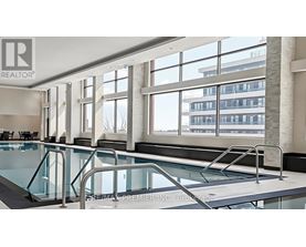 A swimming pool inside a building with a Realtor sign.