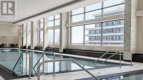 A swimming pool inside a building with a Realtor sign.