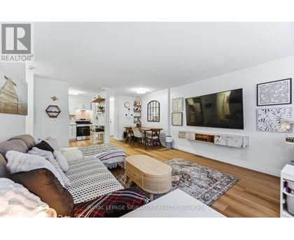 A living room with a couch, a coffee table, and pictures on the wall.