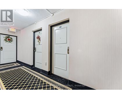 A hallway with three doors and a black and gold floor.