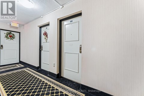 A hallway with three doors and a black and gold floor.