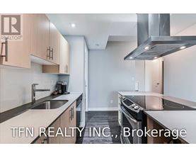 A modern kitchen with a stainless steel oven and a sink with a faucet.