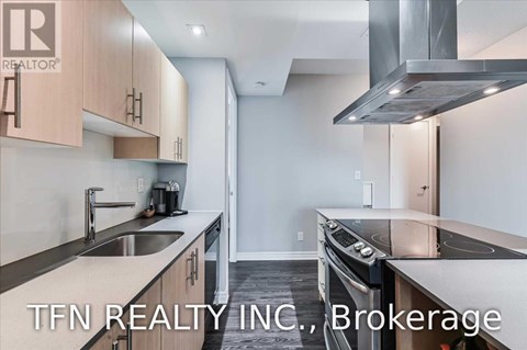 A modern kitchen with a stainless steel oven and a sink with a faucet.