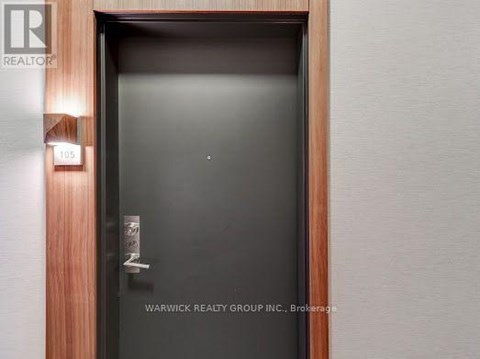A door with a glass panel and a handle is shown with a sign above it that reads "REALTY".
