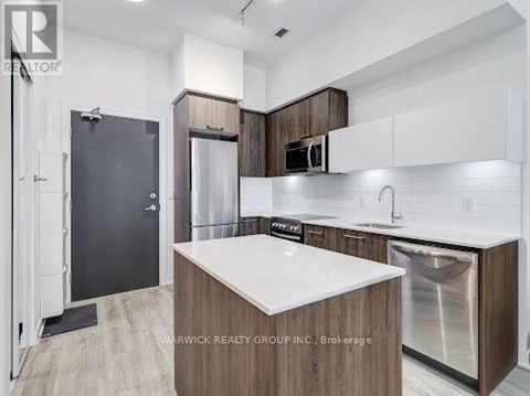 A modern kitchen with a white countertop and wooden cabinets.