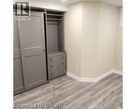A bedroom with a built-in closet and drawers.