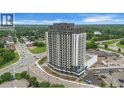 A tall building with a parking lot in front of it.