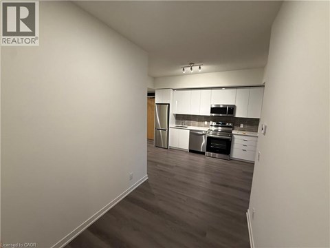 A kitchen with white cabinets and a wooden floor.