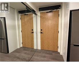 A room with two wooden doors and a refrigerator on the left side.