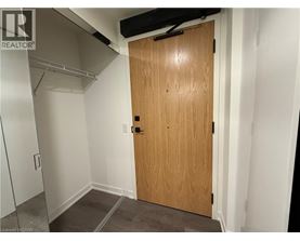 A wooden door in a room with white walls and a grey floor.