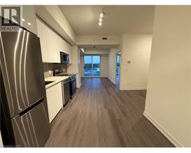 A kitchen with a refrigerator, microwave, and oven.