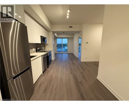 A kitchen with a refrigerator, microwave, and oven.