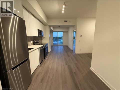 A kitchen with a refrigerator, microwave, and oven.