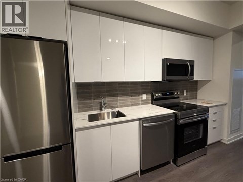 A modern kitchen with white cabinets and stainless steel appliances.