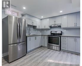 A modern kitchen with stainless steel appliances and white cabinets.