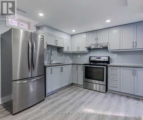 A modern kitchen with stainless steel appliances and white cabinets.