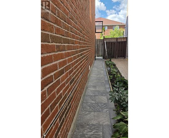 A brick wall with a grey pathway in front of it.