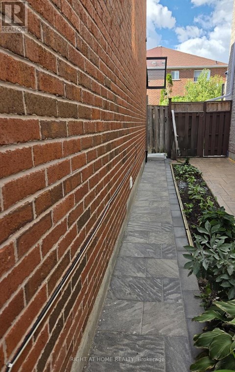 A brick wall with a grey pathway in front of it.