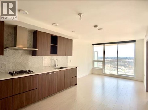 A modern kitchen with wooden cabinets and a marble backsplash.