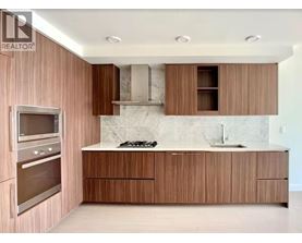 A modern kitchen with wooden cabinets and a marble backsplash.