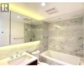 A bathroom with a marble wall and a bathtub.