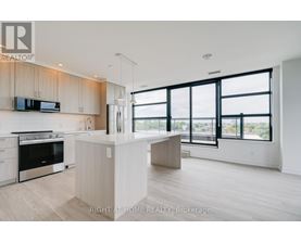 A modern kitchen with a large island and a view of the city.