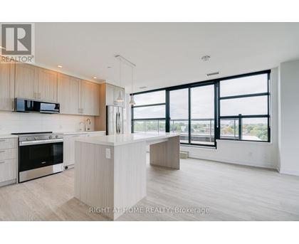 A modern kitchen with a large island and a view of the city.