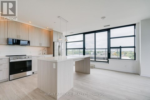 A modern kitchen with a large island and a view of the city.