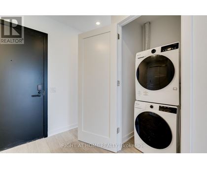 A washing machine is in a small room with a door.
