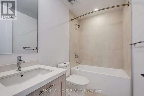 A white bathroom with a sink, toilet, and bathtub.