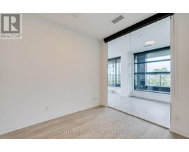 A spacious, empty room with a large window and sliding glass door.