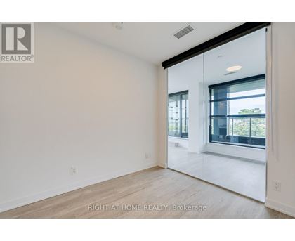 A spacious, empty room with a large window and sliding glass door.