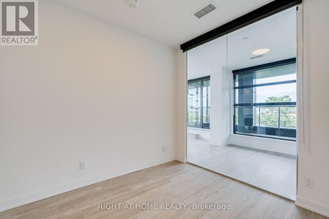 A spacious, empty room with a large window and sliding glass door.