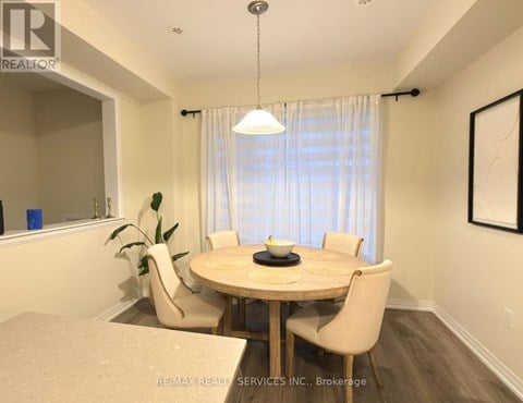 A dining room with a round table and chairs.