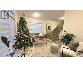 A living room with a Christmas tree and a staircase.