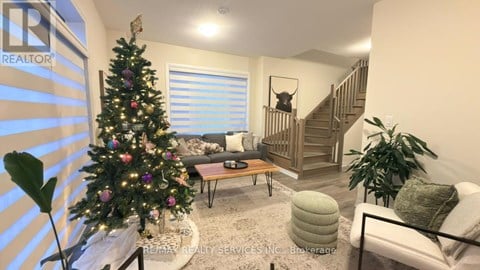 A living room with a Christmas tree and a staircase.