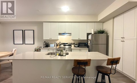 A modern kitchen with white cabinets and a central island.