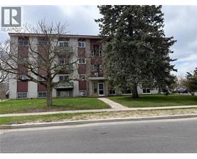 A tall apartment building with a tree in front of it.
