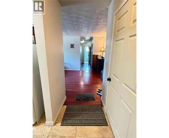 A hallway with a rug on the floor leading to a door.