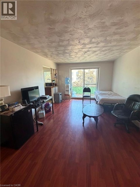 A room with a wooden floor and a ceiling with a textured finish.
