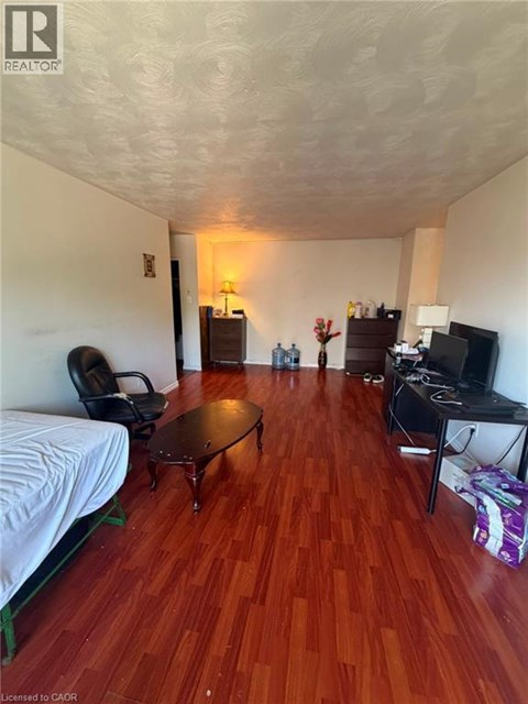 A living room with a wooden floor and a white ceiling.