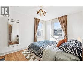 A bedroom with two beds and a mirror on the wall.