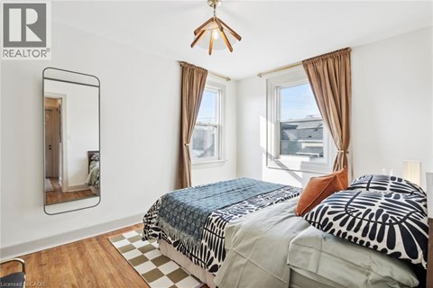 A bedroom with two beds and a mirror on the wall.