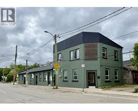 A green building with a black roof and a no parking sign in front of it.
