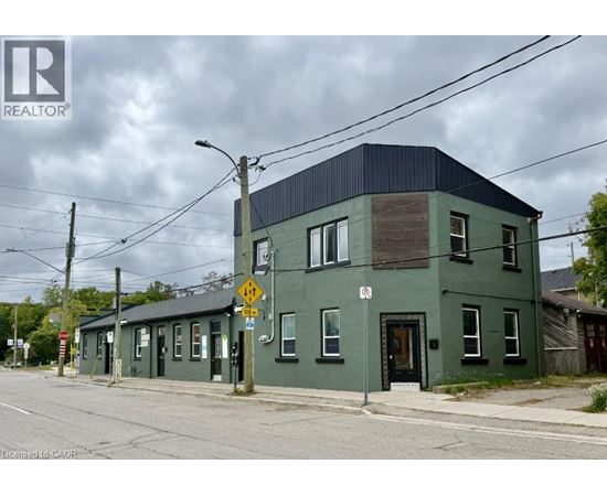 A green building with a black roof and a no parking sign in front of it.